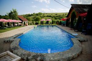 ein großer Pool mit blauem Wasser vor einem Haus in der Unterkunft Giandra Resort in Turda