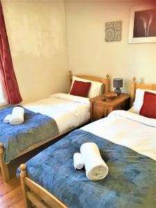Heddfan (Place of Peace) في Llanboidy: غرفة نوم بثلاث اسرة عليها مناشف