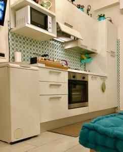 a kitchen with white cabinets and a microwave at La Casa Di Hoby in Naples