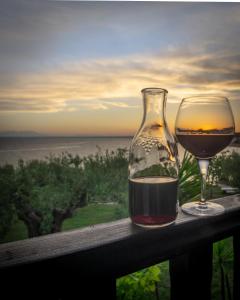 un verre de vin assis sur un rail avec vue dans l'établissement Villa Kalliopi, à Gerakini