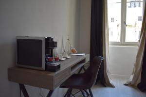 a room with a desk with a tv and a chair at Gatto Bianco Duchessa in Bari