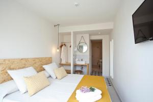 a bedroom with a large white bed with a mirror at BJ Cala Morlanda Estudios in S'Illot