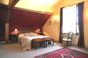 a bedroom with a bed and a table and a window at Moulin du Fief Gentil in Bléré