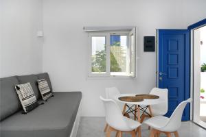 una stanza con tavolo, sedie e porta blu di 21 luxury apartments a Naoussa