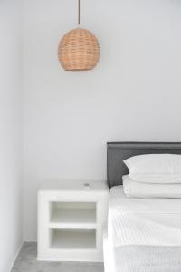 una camera con letto bianco, comodino e lampada di 21 luxury apartments a Naoussa