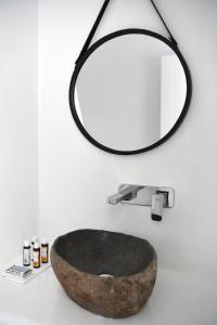 bagno con lavandino in pietra e specchio di 21 luxury apartments a Naoussa