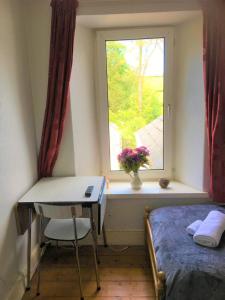 una camera con letto e finestra con scrivania di Heddfan (Place of Peace) a Llanboidy