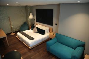 Habitación de hotel con cama y sofá en Casa Prim Hotel Boutique, en Ciudad de México
