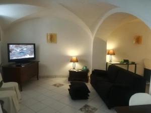 ein Wohnzimmer mit einem Sofa und einem Flachbild-TV in der Unterkunft Casa Vacanze Gaia in Biancavilla
