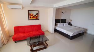 1 dormitorio con cama roja y sofá rojo en Kobuleti Beach Club, en Kobuleti