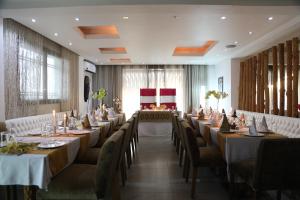 un comedor con mesas y sillas largas en The Swiss Hotel Freetown, en Freetown