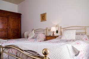 a bedroom with two beds and a wooden cabinet at Danya Country Villa in Sansepolcro