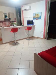 - une cuisine avec deux tabourets rouges dans une pièce dans l'établissement Casa Vacanza le Moko', à Naples