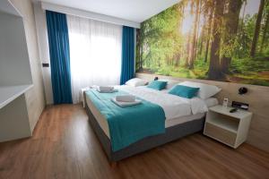 a bedroom with a large bed with a painting on the wall at Apartment Zara Sarajevo in Sarajevo