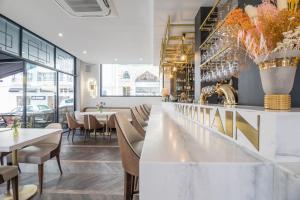 a restaurant with tables and chairs and a bar at Hôtel Cosmopolitain in Biarritz