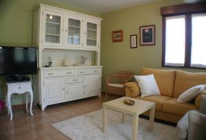 a living room with a couch and a tv at Fonte San Pedrín in Cajide
