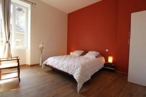una camera con letto e parete rossa di Appartement Spacieux et confortable a Châteaubourg