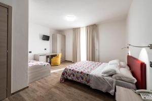 a hotel room with a bed and a desk at Hotel Ristorante Vecchia Maremma in Orbetello