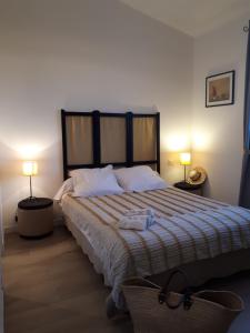 - une chambre avec un grand lit et deux lampes dans l'établissement Les Coronilles, à Saint-Maximin-la-Sainte-Baume