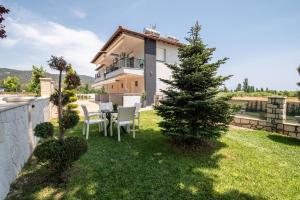 a house with a table and chairs in a yard at A Ponte Studios & Apartments in Sykia Chalkidikis