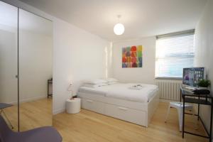Habitación blanca con cama y escritorio en Camden Town Spacious 2 Bedroom Apartment - Sleeps 5 guests! en Londres