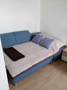 una cama azul con almohadas en una habitación en Mieszkanie Świdnik, en Świdnik