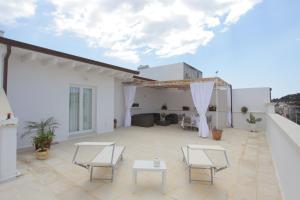 a patio with chairs and tables on a white building at La Bianca Terrazza in Alessano