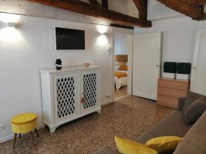 salon z kanapą i telewizorem na ścianie w obiekcie Stefany's Home Venice Apartment w Wenecji