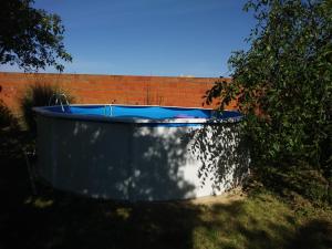 Villa el Gallo في Los Cortijos: حوض استحمام أزرق كبير يجلس بجوار جدار من الطوب