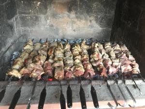 a bunch of meats are cooking on a grill at Guest House 293 in K'obulet'i