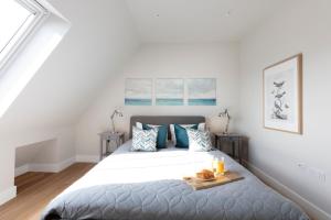 a white bedroom with a bed with a tray on it at Hampden Apartments - The Richard in Windsor