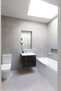 y baño con aseo, lavabo y bañera. en Hampden Apartments - The Richard en Windsor