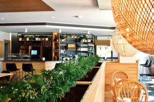 a restaurant with tables and chairs and plants at Camping Preguntoiro in Sanxenxo