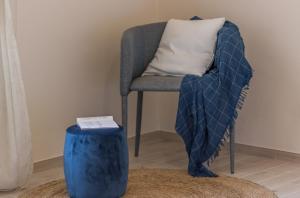 a chair with a blanket on it next to a stool at Casa del Teatro in Città della Pieve