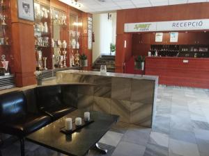 un bar dans un magasin avec un canapé en cuir et une table dans l'établissement Sport Hotel, à Tatabánya