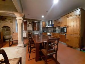 uma grande cozinha com uma mesa de madeira e cadeiras em Casa do Cerrado em Montalegre
