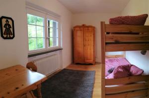 a bedroom with a bunk bed and a desk and a window at Familien- und Sportappartements Wetzel in Menzenschwand