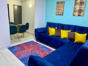 Sofá azul en la sala de estar con alfombra en Aloha Hostel, en Bogotá
