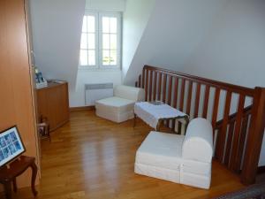 a living room with white furniture and a staircase at LE BOUT DE LA VILLE in Hirel
