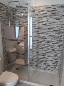 a bathroom with a toilet and a glass shower at De Luxe Apartment South Tenerife in Costa Del Silencio