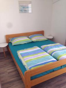 a bed in a bedroom with two pillows on it at Villa M - 4 Persons Apartment, Put in Ljubač