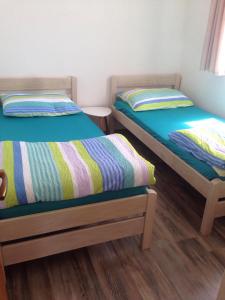 two twin beds in a room with wooden floors at Villa M - 4 Persons Apartment, Put in Ljubač