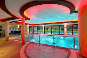 a large indoor swimming pool with a red ceiling at Familienhotel Oberkarteis in Hüttschlag