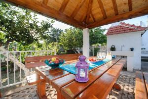 una mesa de picnic de madera con una botella púrpura. en Holiday Home Koprivno, en Koprivno