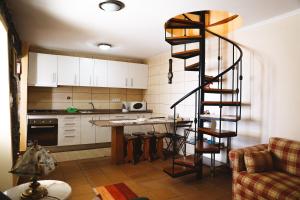 a kitchen with a spiral staircase in a room at Raposeira Chloe T2 in Fajã da Ovelha