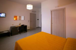 a bedroom with a orange bed and a desk and a table at Rotte e Sentieri B&B in Castelluzzo