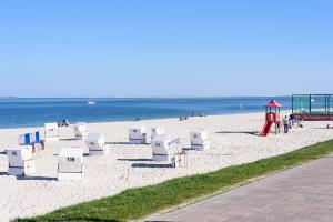 a beach with a bunch of chairs and a playground at Hûs lepen Wil in Hörnum