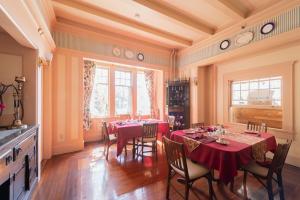 a dining room with a red table and chairs at Beaconsfield Bed and Breakfast - Victoria in Victoria