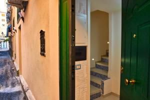 un couloir avec une porte verte et quelques escaliers dans l'établissement Casa sul Corso, à Salerne