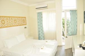 a white bedroom with a bed and a window at Kemer Park Otel in Kemer